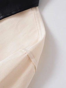 Detail of cream canvas and black leather stitching on casual short utility jacket