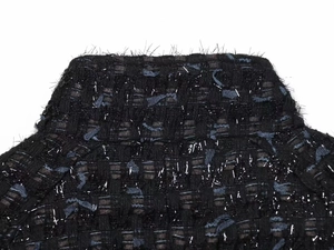 Close-up of black tweed jacket collar with metallic threads and frayed edge detail
