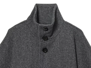 Detailed view of high-neck wool-blend coat with three glossy black buttons in dark grey