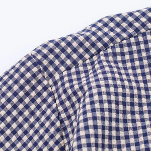 Close-up of blue and white gingham seersucker fabric and neat collar stitching
