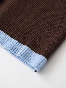 Detailed close-up of ribbed knit cuffs in contrasting dark brown and sky blue tones
