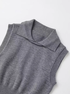 Détail du gilet en maille grise avec col à revers et texture côtelée délicate