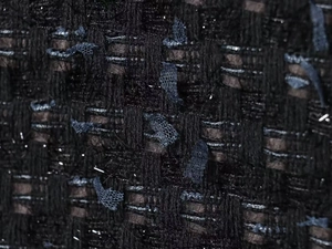 Macro shot of premium tweed fabric with metallic threads and textured lace ribbon detail
