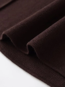 Primo piano della texture in maglia marrone scuro con onde morbide e maglie fitte