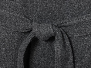 Macro detail of charcoal wool fabric texture and tie-waist belt on a chic winter coat