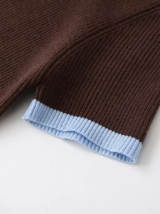 Detailed close-up of dark brown knit texture with light blue contrast ribbed edge