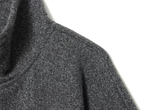 Detailed close-up of dark grey high collar poncho coat showing thick wool blend texture