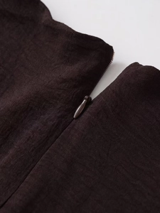 Close-up of the dark brown midi dress featuring a hidden zipper and woven texture