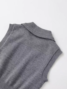 Détail du gilet en maille grise avec col polo et finitions en maille côtelée