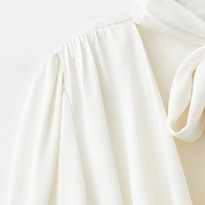 Blouse élégante en satin blanc à manches longues avec détails plissés et col à nouer