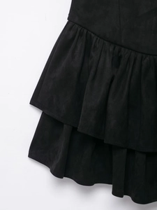 Detail shot of black faux suede tiered skirt showing layered ruffles and fabric texture