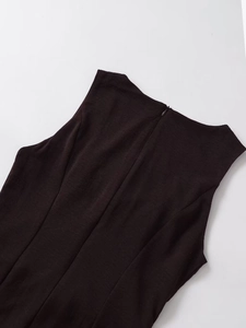 Close-up of invisible zipper closure and textured fabric on the back of a black midi dress