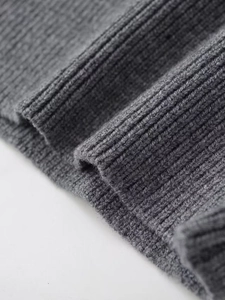 Gros plan détaillé du gilet en maille grise montrant la texture et la finition côtelée
