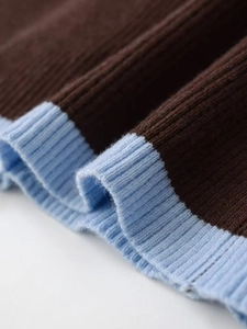 Close-up of dark brown knit fabric with light blue ribbed cuffs and texture