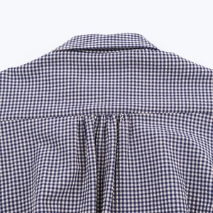 Detail of blue and white gingham shirt showing the collar and pleats on the back yoke