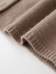 Close-up of warm camel knit sweater texture with soft fluffy fibers and ribbed cuffs