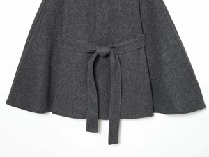 Detail of charcoal grey wool-blend coat showing fabric texture and tied waist belt