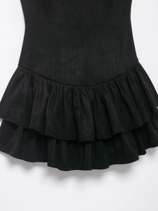 Detailed close-up of black suede texture and layered ruffle hem on the dress