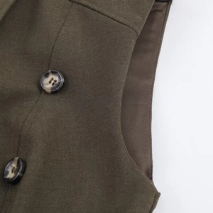 Detail of olive woven fabric featuring tortoiseshell buttons and precise stitching