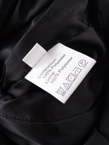 Détail montrant la composition 100% polyester et les symboles d'entretien sur l'étiquette