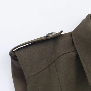 Macro detail of army green shirt featuring shoulder epaulet and marbled button texture