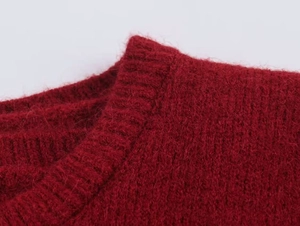 Macro detail of red knit sweater collar with plush mohair texture and ribbed neckline