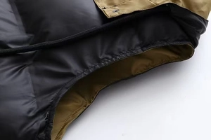 Détail du tissu matelassé et des coutures color-block sur le gilet à capuche