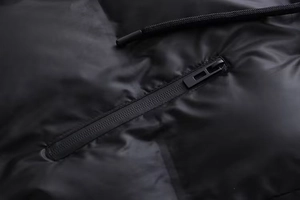 Détail de la poche de gilet avec fermeture éclair noire et cordon de serrage tissé