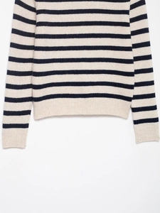 Detail shot of navy and cream striped knit sweater featuring ribbed cuffs and soft texture