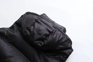 Détail du gilet matelassé noir à col montant montrant la texture du tissu et les épaules