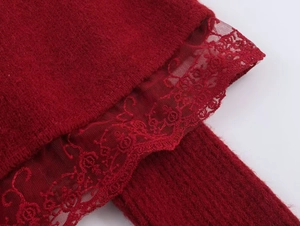 Detail of burgundy knit fabric with elegant lace floral embroidery trim on the sleeve