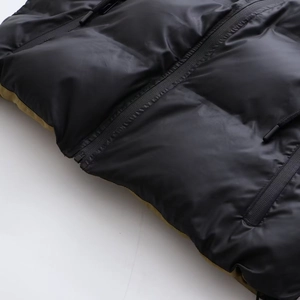 Détail de la veste noire brillante avec doublure vert olive et fermeture éclair noire