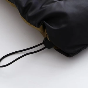Détail du cordon élastique réglable et du fermoir sur le tissu de la veste matelassée