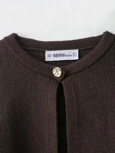 Detail of round neck brown knit cardigan with golden button and brand neck label