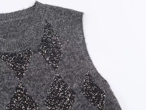 Detail of dark grey knit vest with black sequin argyle pattern and fuzzy plush texture