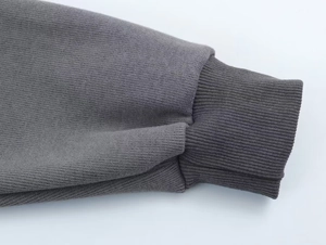 Macro shot of dark grey ribbed cuff detailing on high-density knit hoodie sleeves