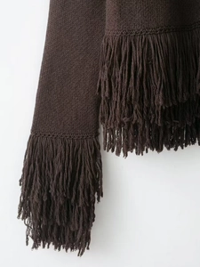 Detail shot of the long fringe tassels on the cuffs of a coffee brown knitted sweater