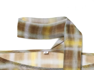 Detail showing the neckline, size S tag, and tan plaid fabric texture of the blouse