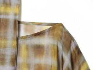 Detail of plaid gradient chiffon fabric with neat stitching on the collar and shoulder