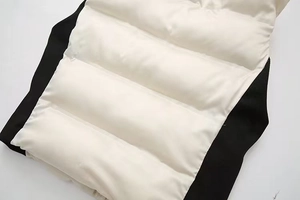 Détail macro du gilet matelassé avec empiècements latéraux en maille côtelée noire