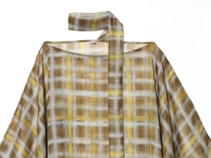 Detail of yellow plaid pattern top showing asymmetric neckline and matching scarf ribbon