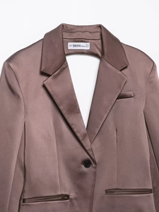 Dettaglio macro del colletto del blazer in raso marrone scuro con finitura lucida setosa