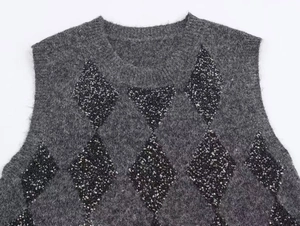 Detail of dark grey fuzzy knit vest featuring black sequined diamond patterns and round neck