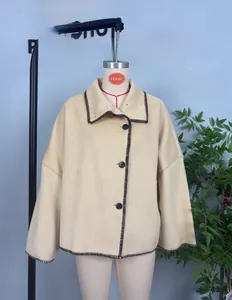 Detail of beige wool coat with dark brown contrast stitching and black buttons