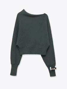 Detail of off-shoulder dark grey knit top with ribbed hem and metallic buckle on sleeve