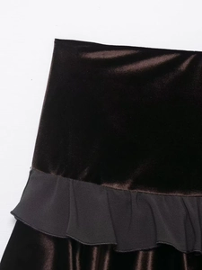 Detail of dark velvet fabric with pleated black ruffle hem on high-waist mini skirt