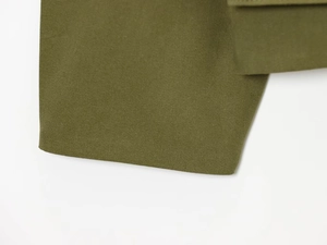 Detailed macro view of olive green canvas fabric texture on a durable autumn jacket