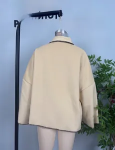 Detail of beige wool jacket back showing brown decorative hand-stitched seams and fit