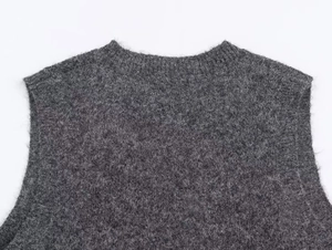 Detail of dark grey fuzzy knit vest featuring a ribbed neckline and soft mohair texture