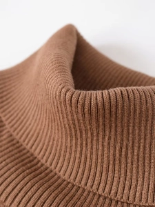Detailed close-up of dark brown ribbed knit fabric on a high-neck turtleneck sweater
